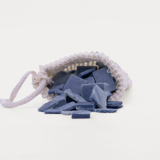 Soap bag with offcuts filled with blue soap pieces spilling out.